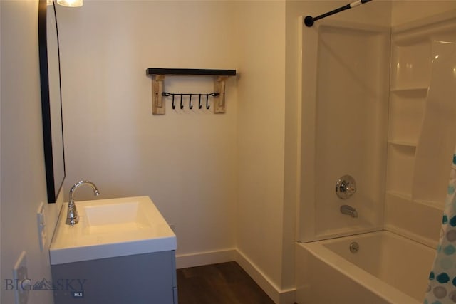 full bath featuring shower / bath combination with curtain, wood finished floors, vanity, and baseboards