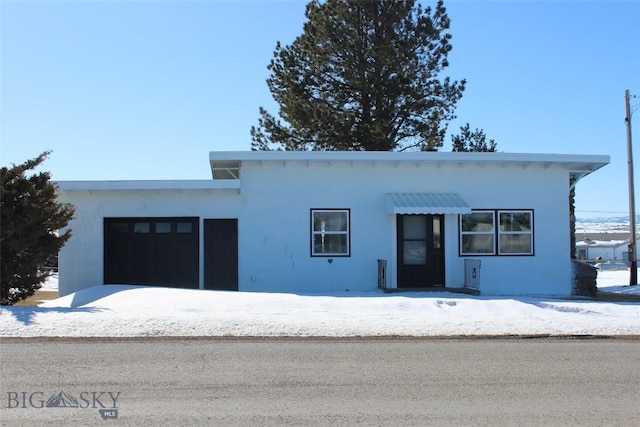 view of front of property featuring an attached garage and stucco siding