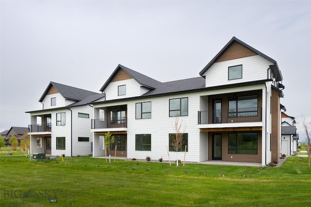 rear view of property featuring a yard, a patio, a balcony, and central air condition unit