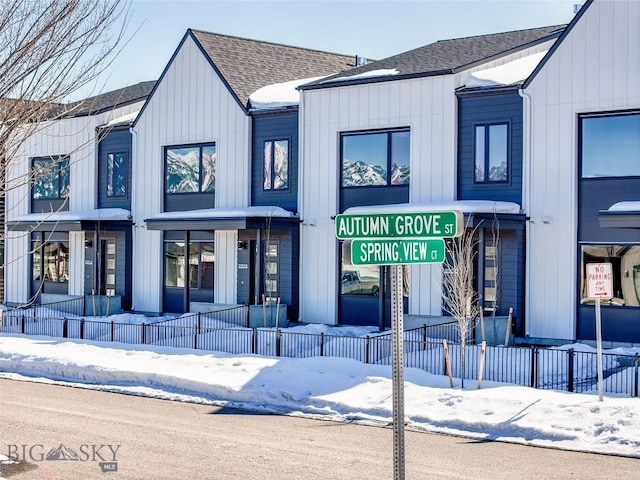 snow covered property with a fenced front yard