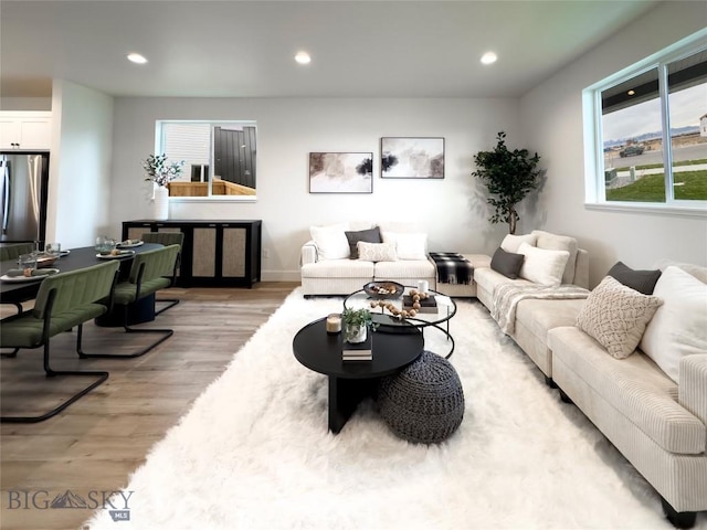 living area with recessed lighting and light wood finished floors