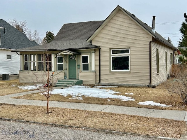 bungalow-style house featuring roof with shingles and central air condition unit