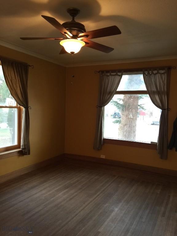 unfurnished room featuring baseboards, ornamental molding, and wood finished floors