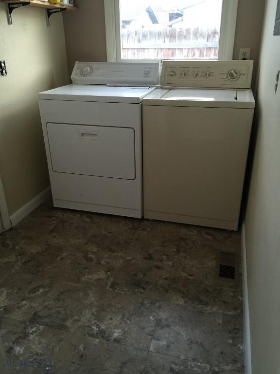 laundry room featuring laundry area, washing machine and dryer, visible vents, and a healthy amount of sunlight