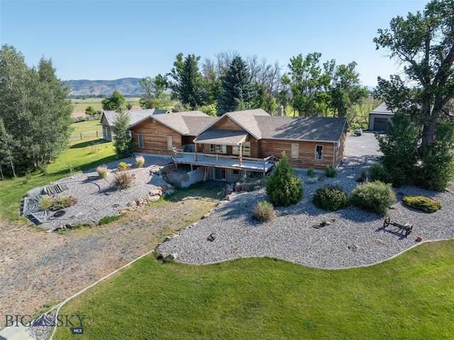 exterior space featuring a front yard and a deck with mountain view