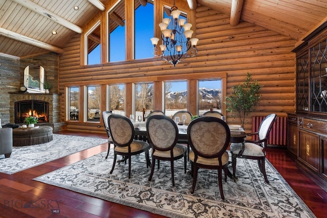 dining room featuring an inviting chandelier, wood ceiling, hardwood / wood-style flooring, and a stone fireplace