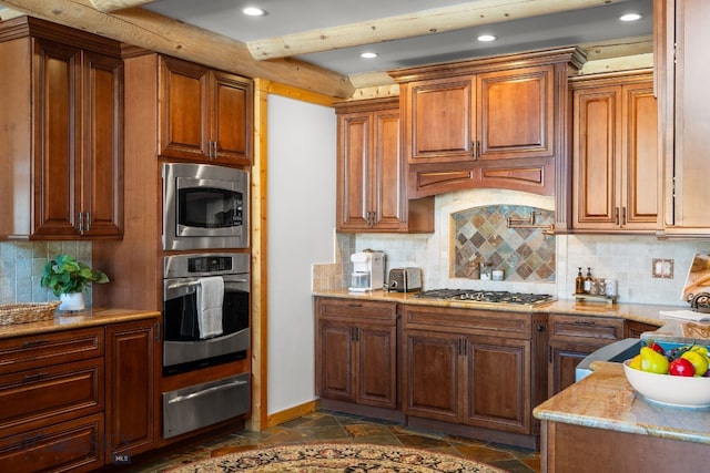 kitchen featuring backsplash, stone tile floors, stainless steel appliances, and a warming drawer