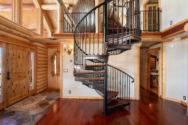 foyer with high vaulted ceiling, wooden ceiling, wood finished floors, and baseboards