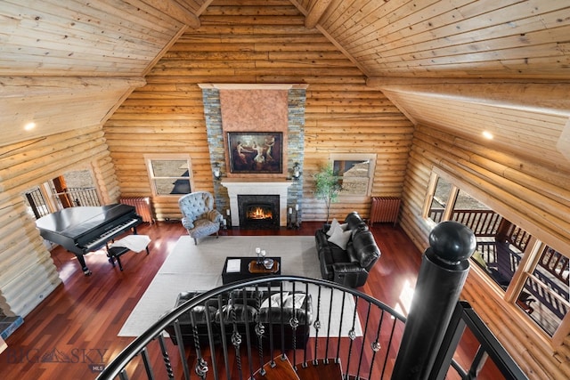 unfurnished living room featuring wood ceiling, high vaulted ceiling, wood finished floors, and a lit fireplace