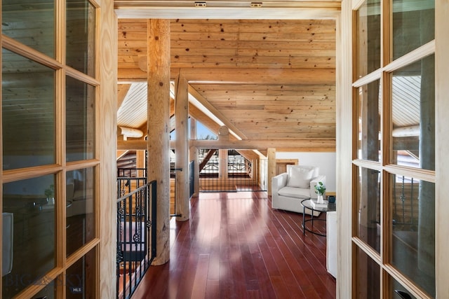 hall with wooden ceiling, vaulted ceiling, dark wood finished floors, and an upstairs landing