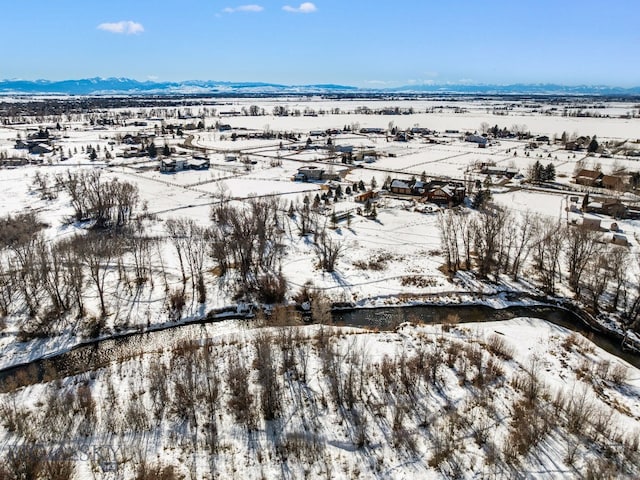 snowy aerial view featuring a mountain view