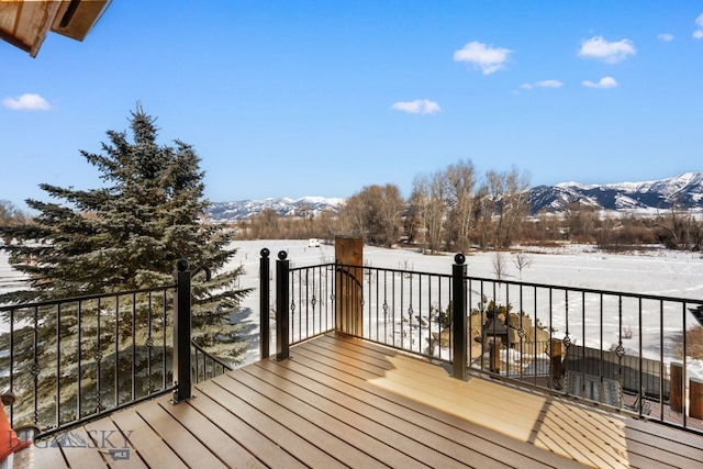 snow covered deck with a mountain view