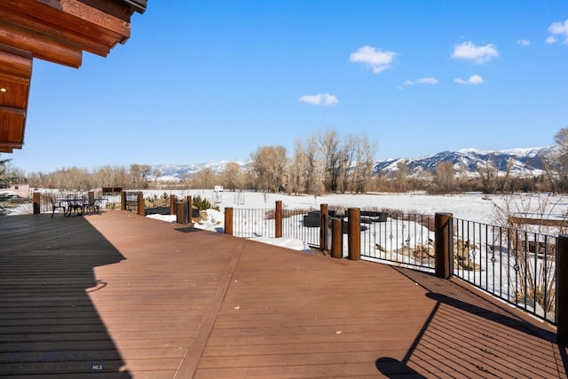 snow covered deck with a mountain view