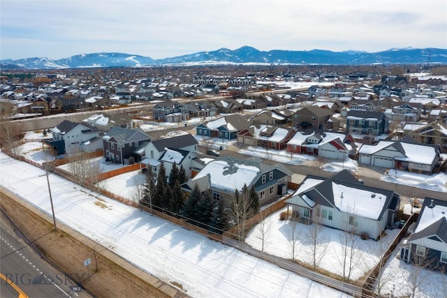 snowy aerial view with a residential view and a mountain view