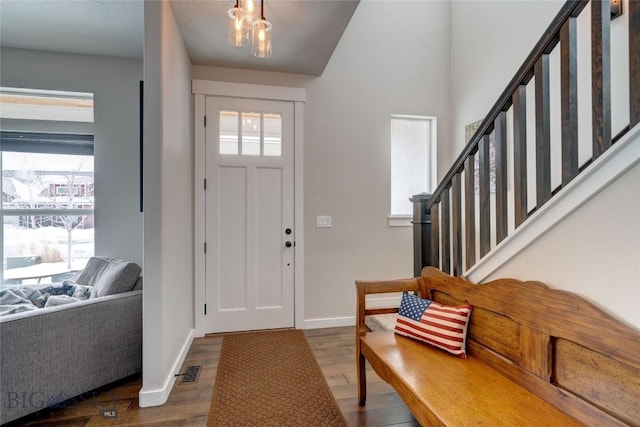 entryway with visible vents, baseboards, wood finished floors, and stairs