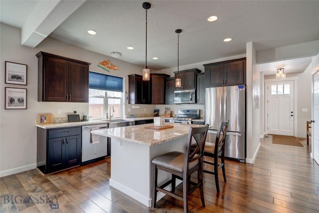 kitchen with a sink, dark brown cabinetry, dark wood-style flooring, and stainless steel appliances