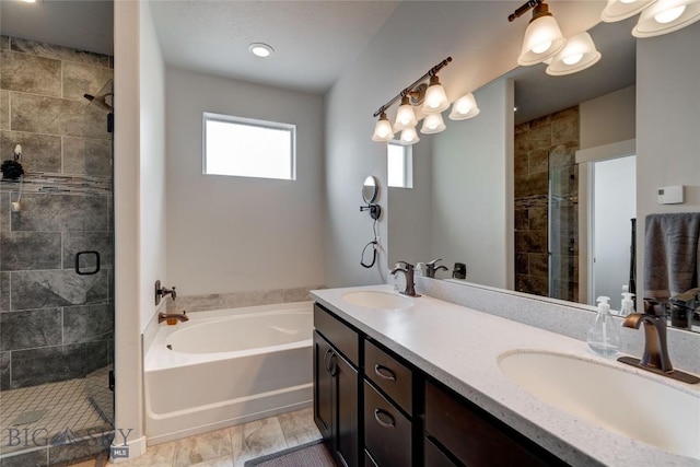 bathroom featuring a bath, a stall shower, and a sink