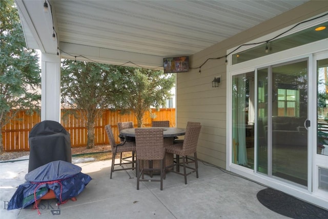 view of patio featuring outdoor dining area and fence