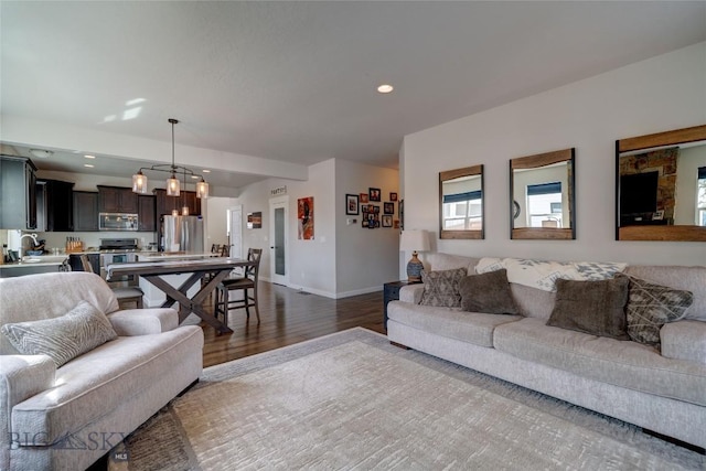 living area with recessed lighting, baseboards, an inviting chandelier, and dark wood-style floors