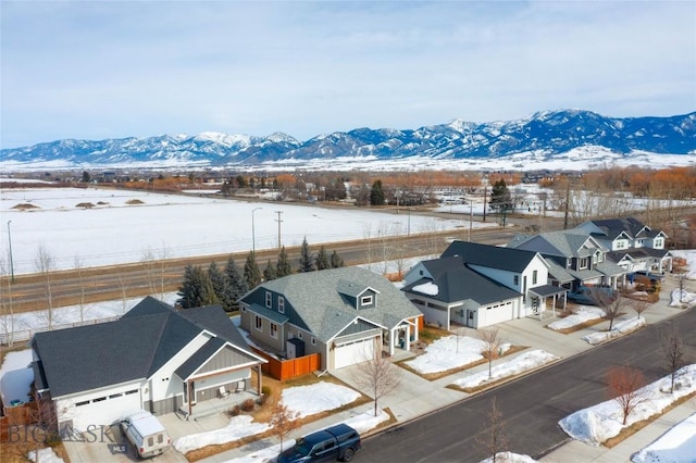 snowy aerial view with a residential view and a mountain view