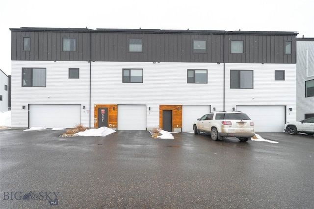 back of house featuring a garage and driveway