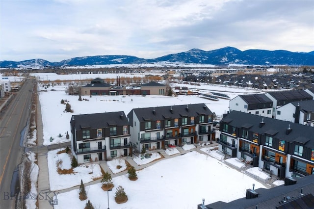 snowy aerial view with a mountain view and a residential view