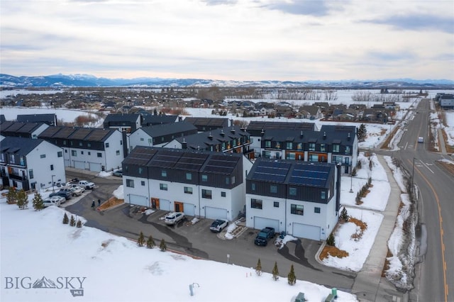 snowy aerial view with a residential view and a mountain view