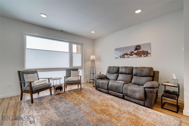 living area featuring recessed lighting, baseboards, and wood finished floors