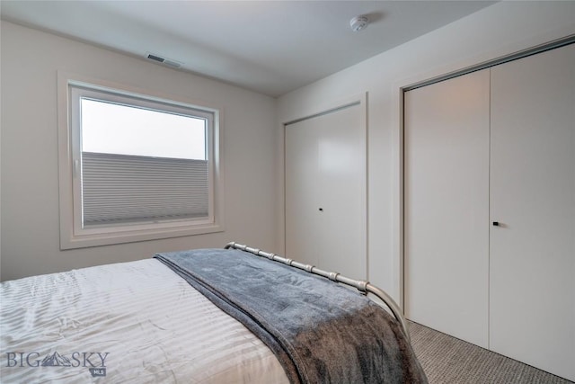 bedroom with visible vents, a closet, and carpet flooring