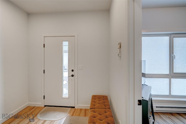 foyer with wood finished floors, baseboards, and baseboard heating