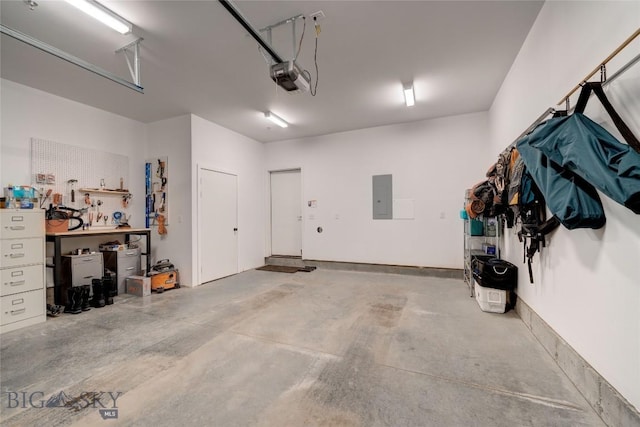 garage featuring electric panel, a workshop area, and a garage door opener