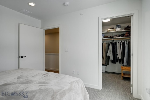 bedroom featuring a spacious closet, baseboards, a closet, and carpet floors