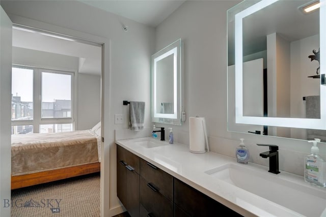 ensuite bathroom featuring a sink, ensuite bath, and double vanity