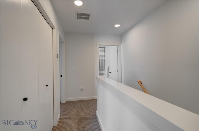 corridor featuring visible vents, an upstairs landing, recessed lighting, dark colored carpet, and baseboards