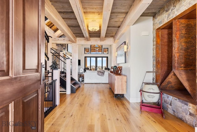 interior space featuring stairs, beam ceiling, light wood-type flooring, and wooden ceiling