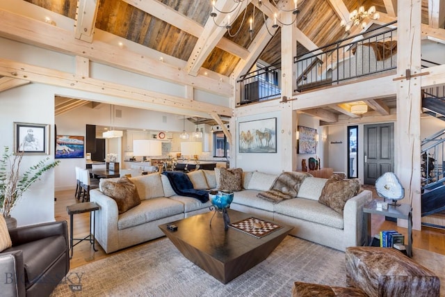 living area featuring wood ceiling, beamed ceiling, wood finished floors, and a chandelier