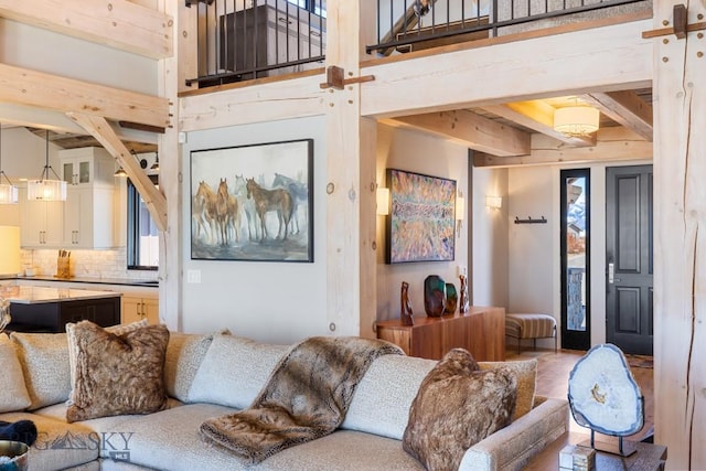 living room with beamed ceiling and a towering ceiling