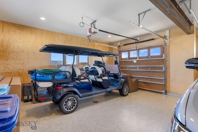 garage featuring a garage door opener and wood walls