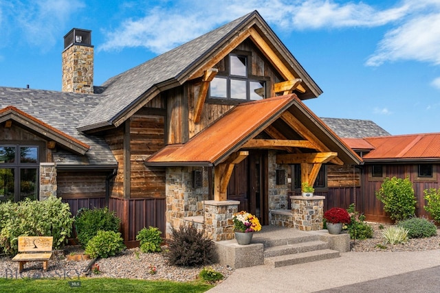 view of front of property featuring stone siding, covered porch, and a chimney