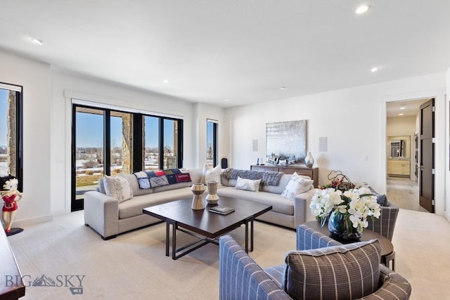 living area with recessed lighting, baseboards, and light carpet