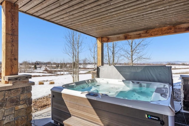 snow covered patio featuring a hot tub