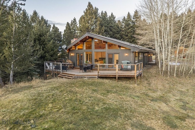 back of house featuring a lawn and a wooden deck