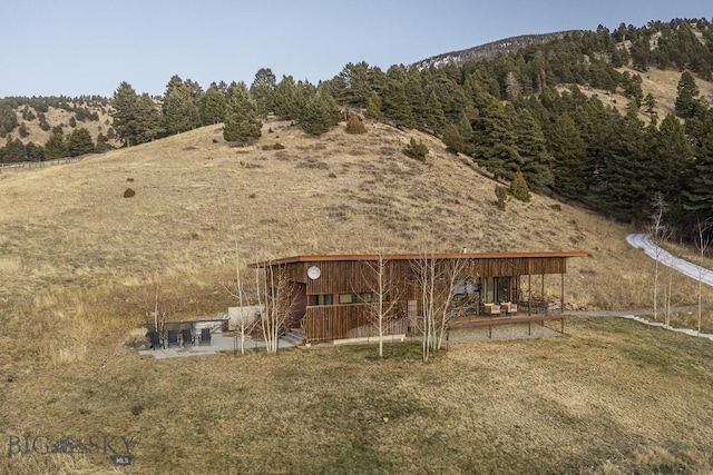 view of yard featuring a view of trees and a patio