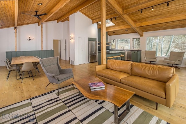 living room with ceiling fan, wooden ceiling, vaulted ceiling with beams, and light wood-style floors