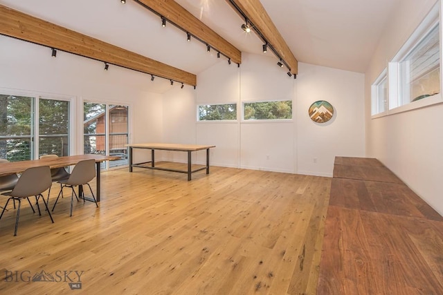 interior space featuring lofted ceiling with beams, light wood-type flooring, and track lighting