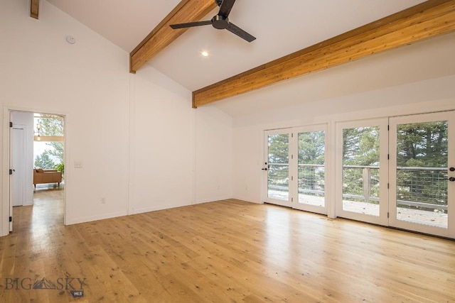 unfurnished living room with a ceiling fan, beamed ceiling, wood finished floors, and a wealth of natural light