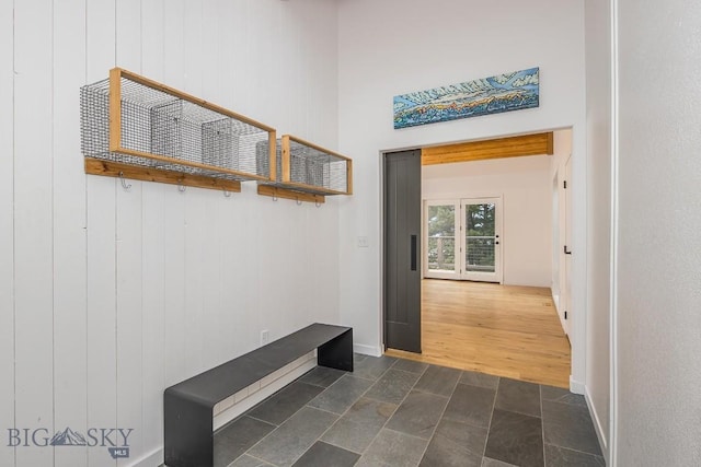 mudroom with dark wood finished floors and baseboards