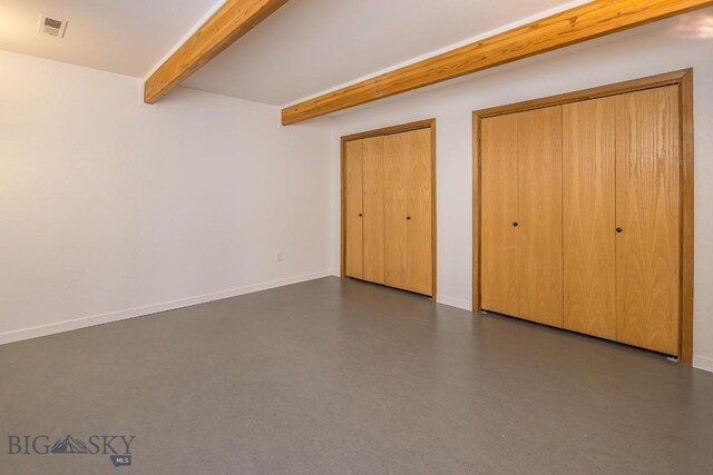 unfurnished bedroom featuring baseboards, beam ceiling, two closets, and visible vents