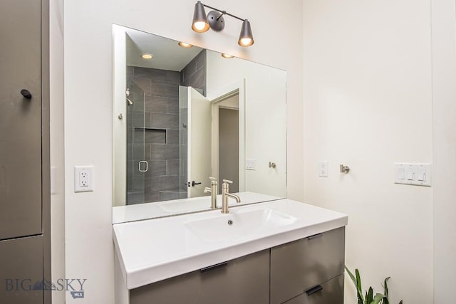 bathroom with tiled shower and vanity