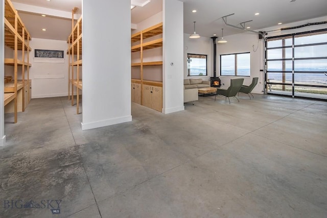 garage with a wood stove, recessed lighting, and baseboards